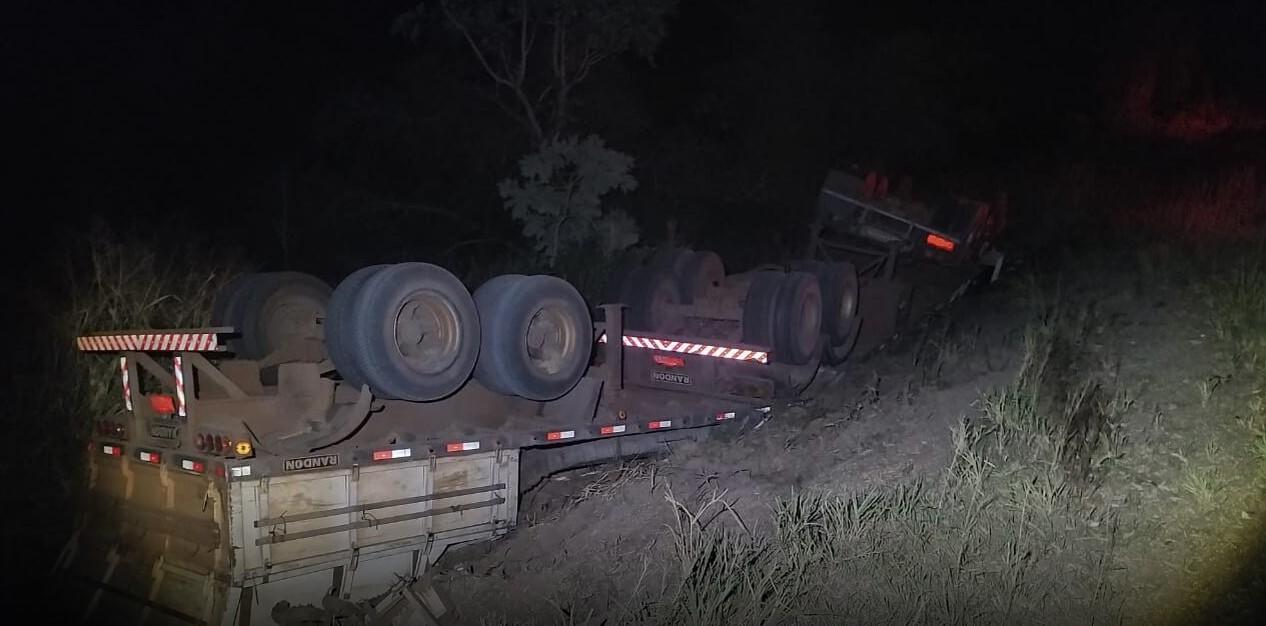 Ao desviar de buraco, caminhoneiro que carregava carga de soja capota